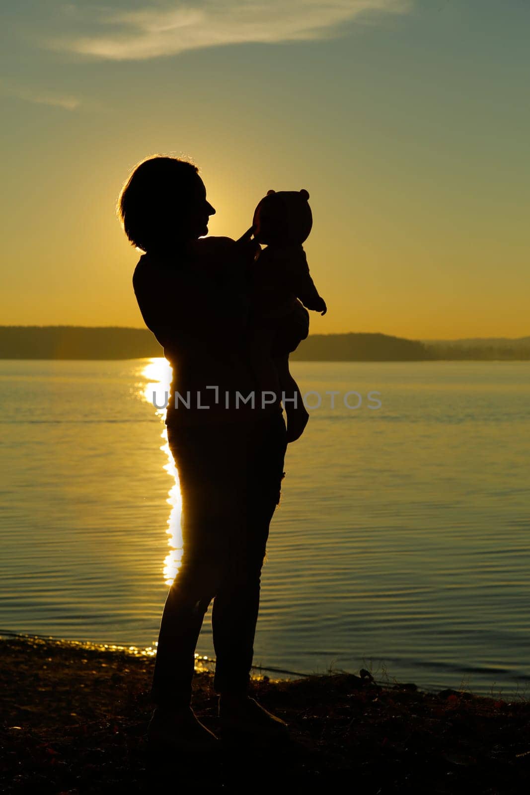 Mom and baby on the beach at sunset against the background of the sea