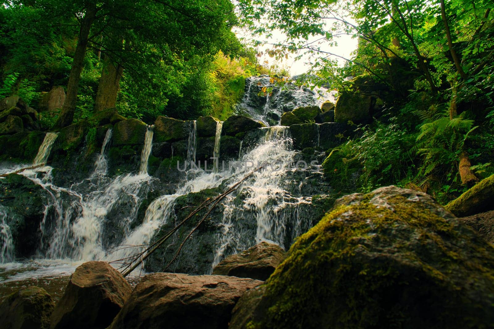 Small waterfall in Sweden. Moss-covered stones. Forest on the river bank. Scandinavian nature