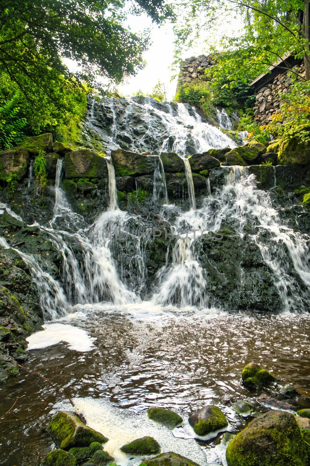 Small waterfall in Sweden. Moss-covered stones. Forest on the river bank. Scandinavian nature