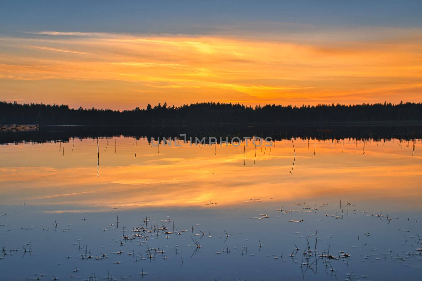 Sunset with warm colors on a Swedish lake in Smalland. Romantic evening atmosphere. Scandinavian nature