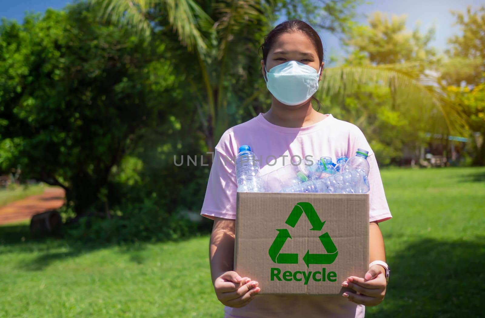 Woman collecting garbage and holding a recycle bin with plastic bottles in the outdoors, Recycle concept, Plastic-free, Junk food plastic packaging, Reduction environmental pollution.