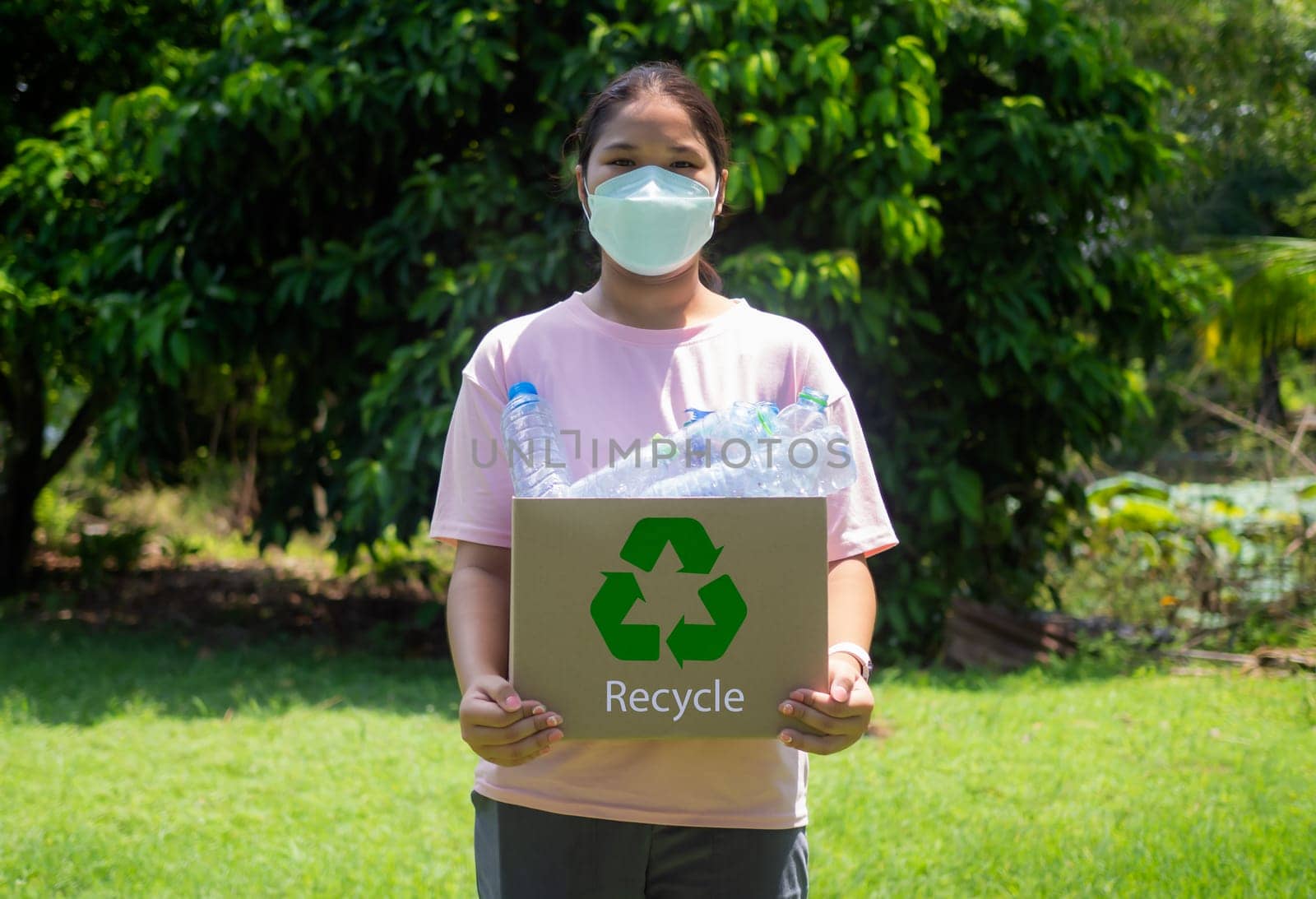 Reduction environmental pollution and recycle concept, woman collecting garbage and holding a recycle bin with plastic bottles in the outdoors, Plastic-free, Junk food plastic packaging.