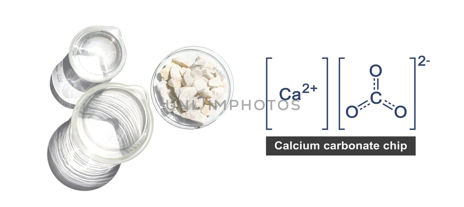 Calcium carbonate chip in chemical watch glass with molecular structure place next to beaker on white laboratory table. Top view