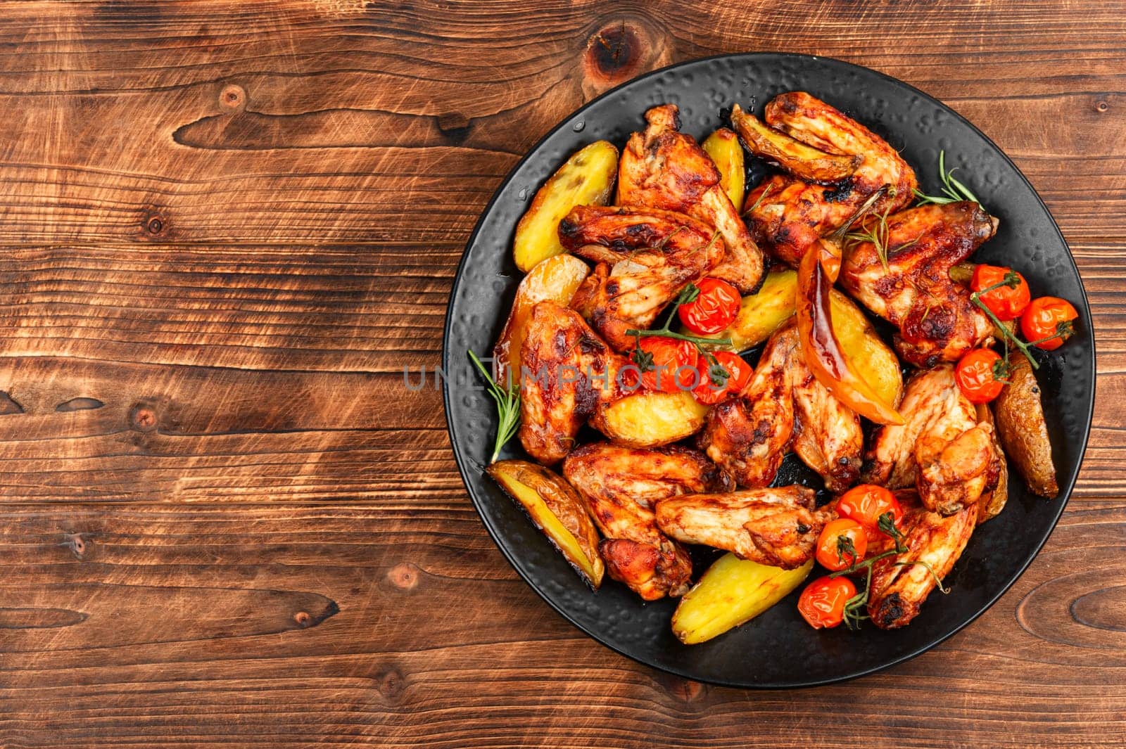 Roasted chicken wings and baked potatoes. BBQ.