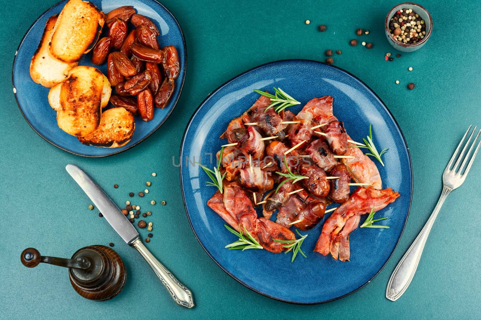 Bacon wrapped date skewers placed, English traditional snack on rustic wooden table. Space for text.
