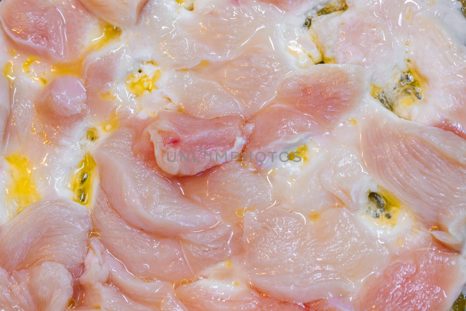 closeup full-frame background of raw chicken breast meat just starting to roast.