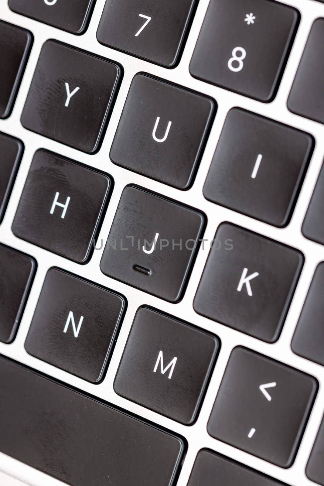 keyboard of famous silver colored laptop with fingerprints, closeup