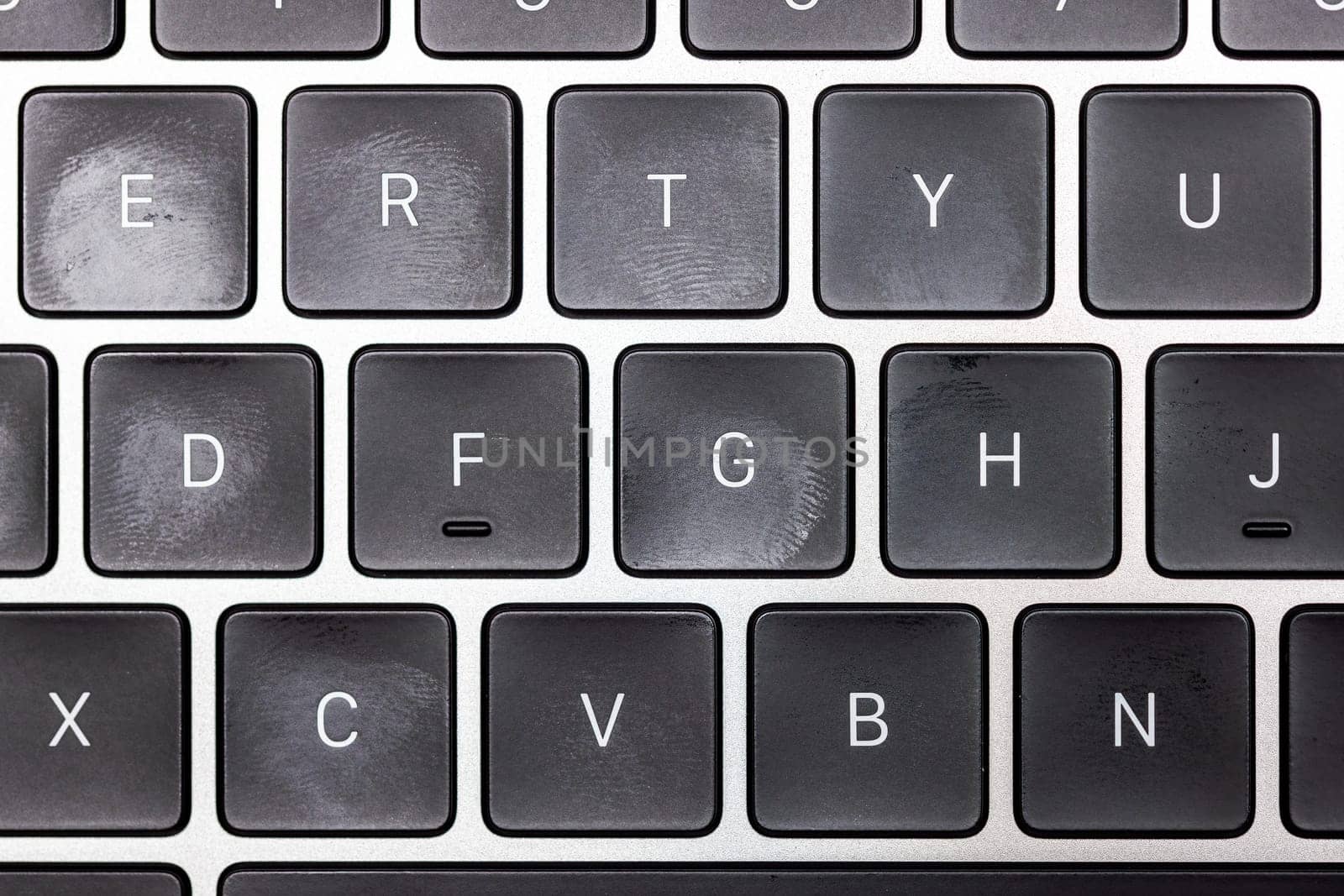 keyboard of famous silver colored laptop with fingerprints, closeup