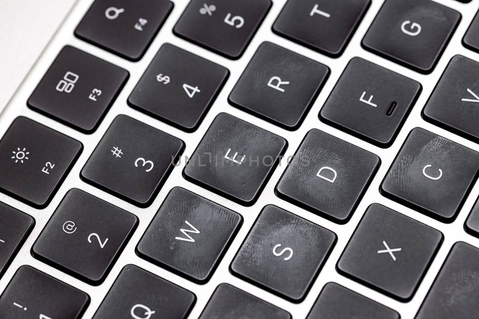 keyboard of famous silver colored laptop with fingerprints, closeup