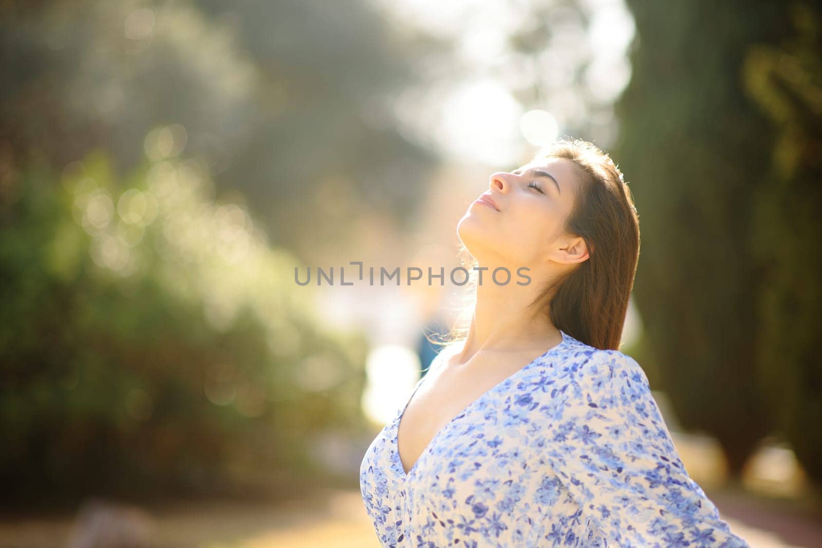 Woman breathing fresh air in a park standing alone