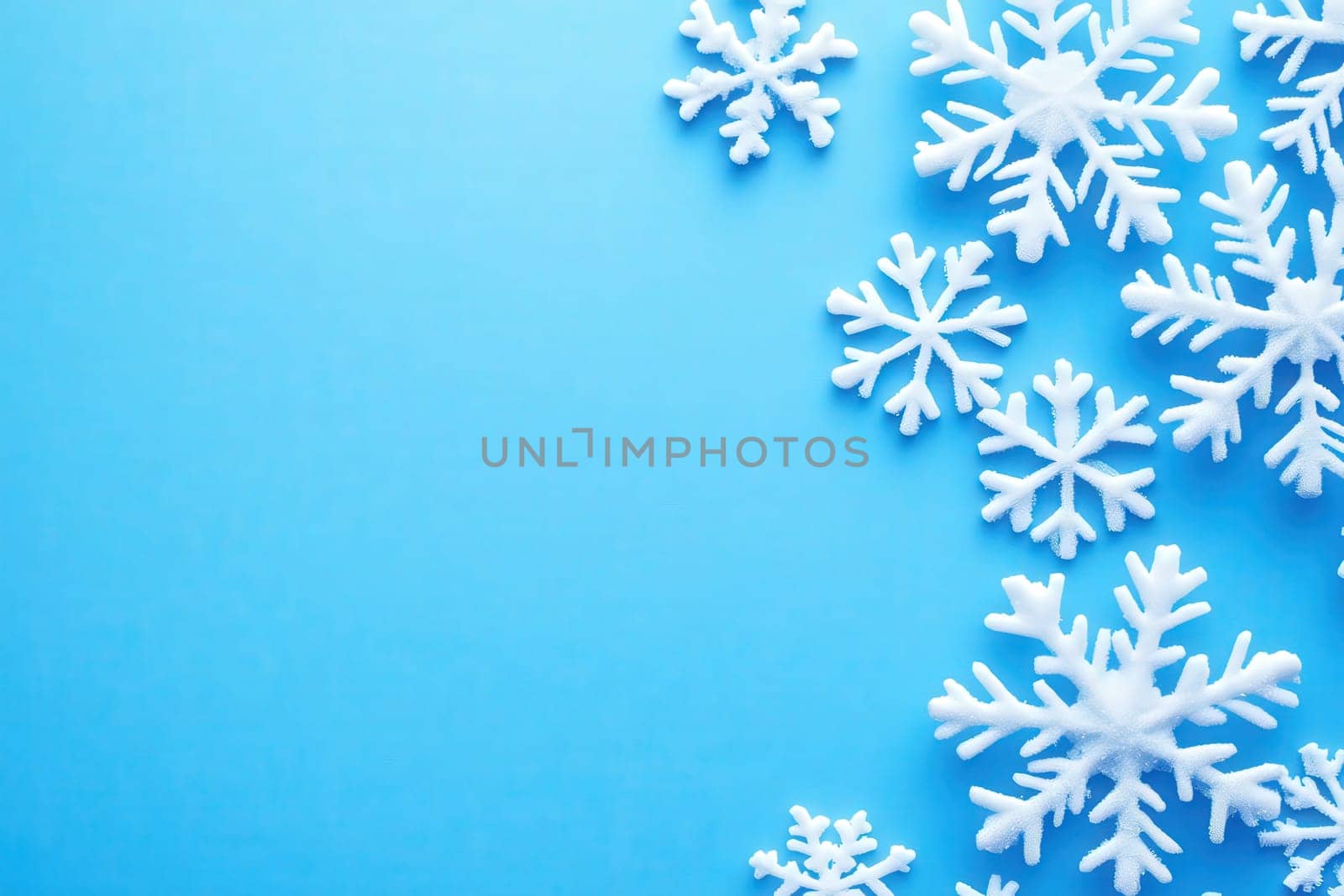 Delicate white snowflakes are artistically arranged on a clean blue background, creating a cheerful winter ambiance. Perfect for celebrating a festive season filled with joy and creativity.