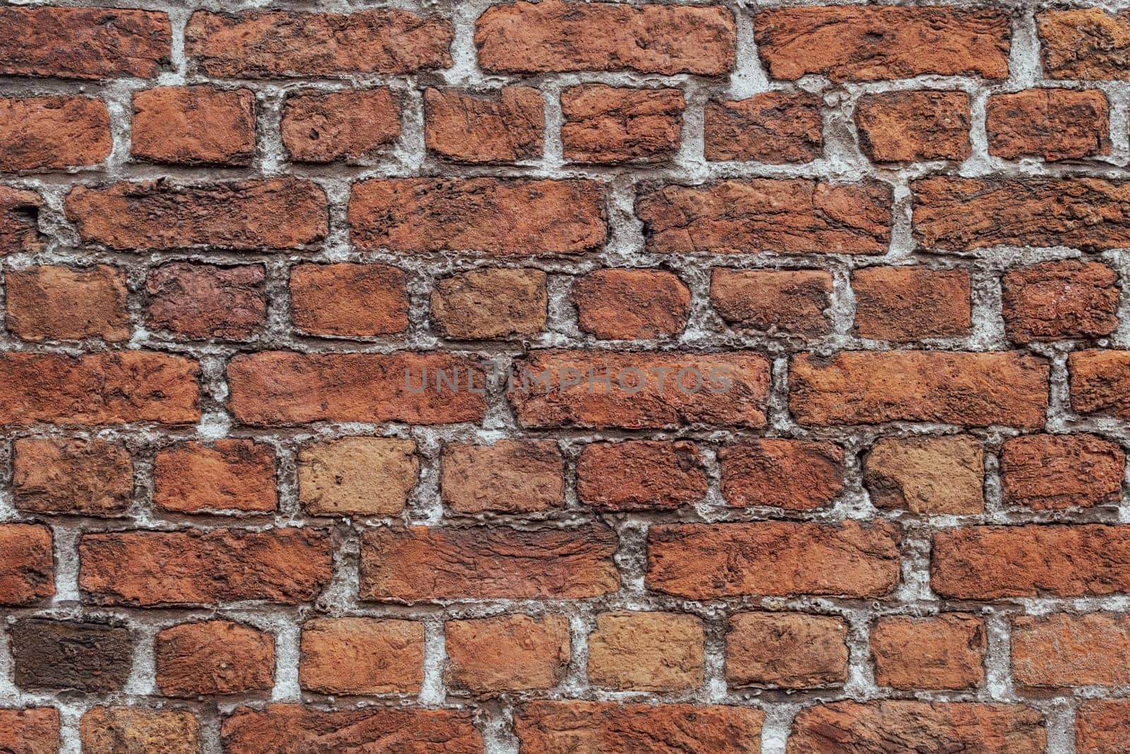 Closeup of an old, weathered wall with reclaimed bricks in irregular patterns