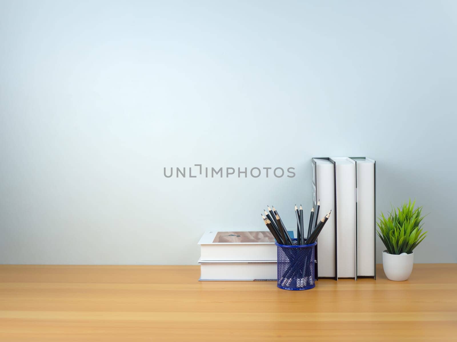 Back to school concept,  Book stack and  Pencil on wooden table workspace area and white wall, Concept of time to study, Read books, Concept of preparing for exams.