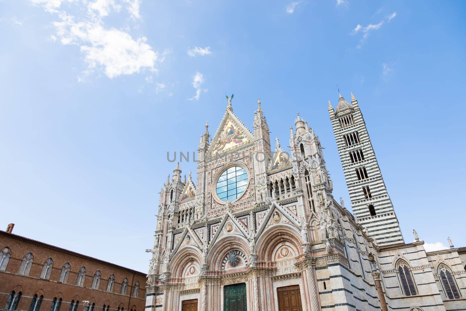 Siena cathedral in Italy. White marbles with blue sky, famous landmark of Tuscany