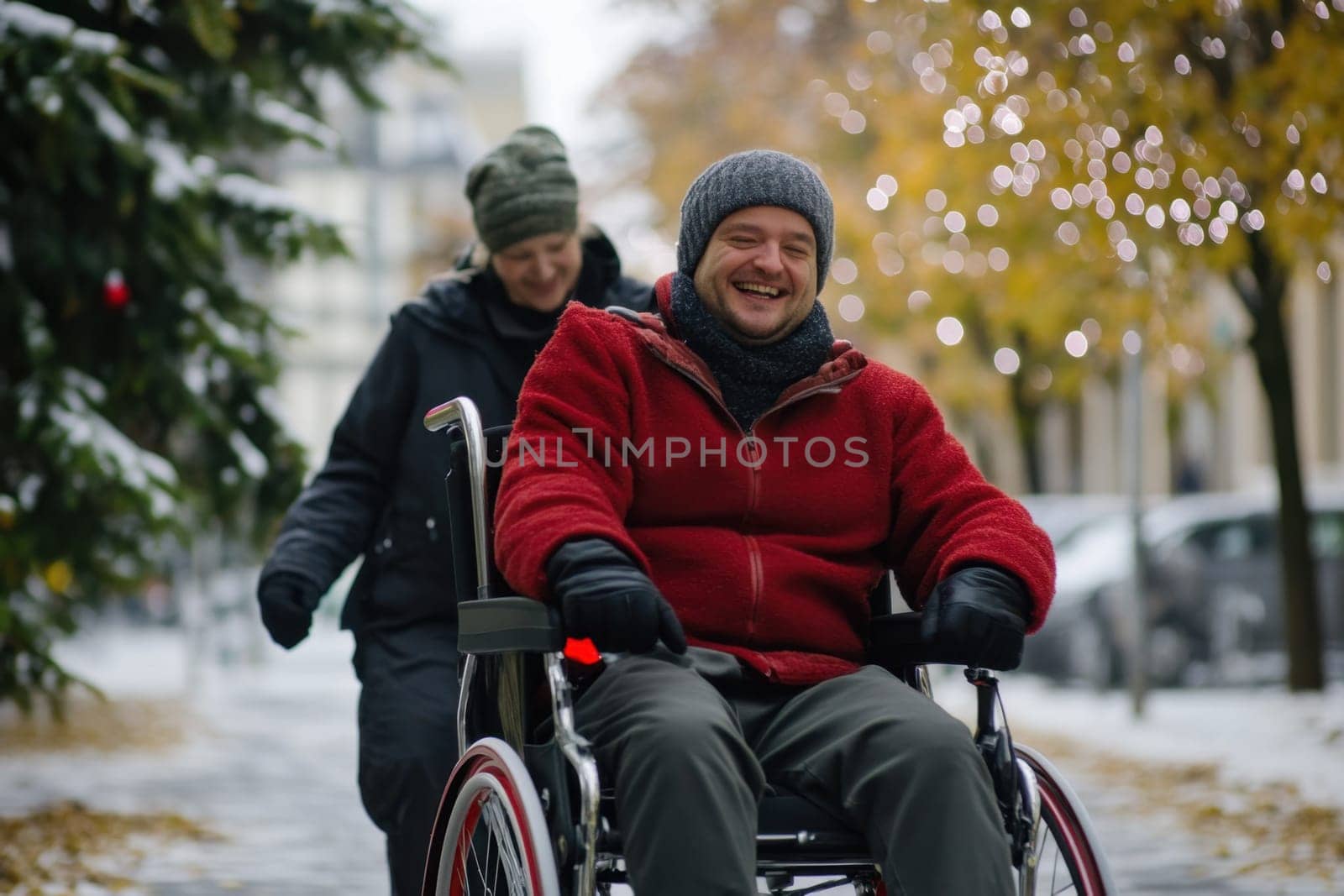 A man in a wheelchair enjoys a cheerful winter walk with a friend surrounded by snowy trees and festive lights.