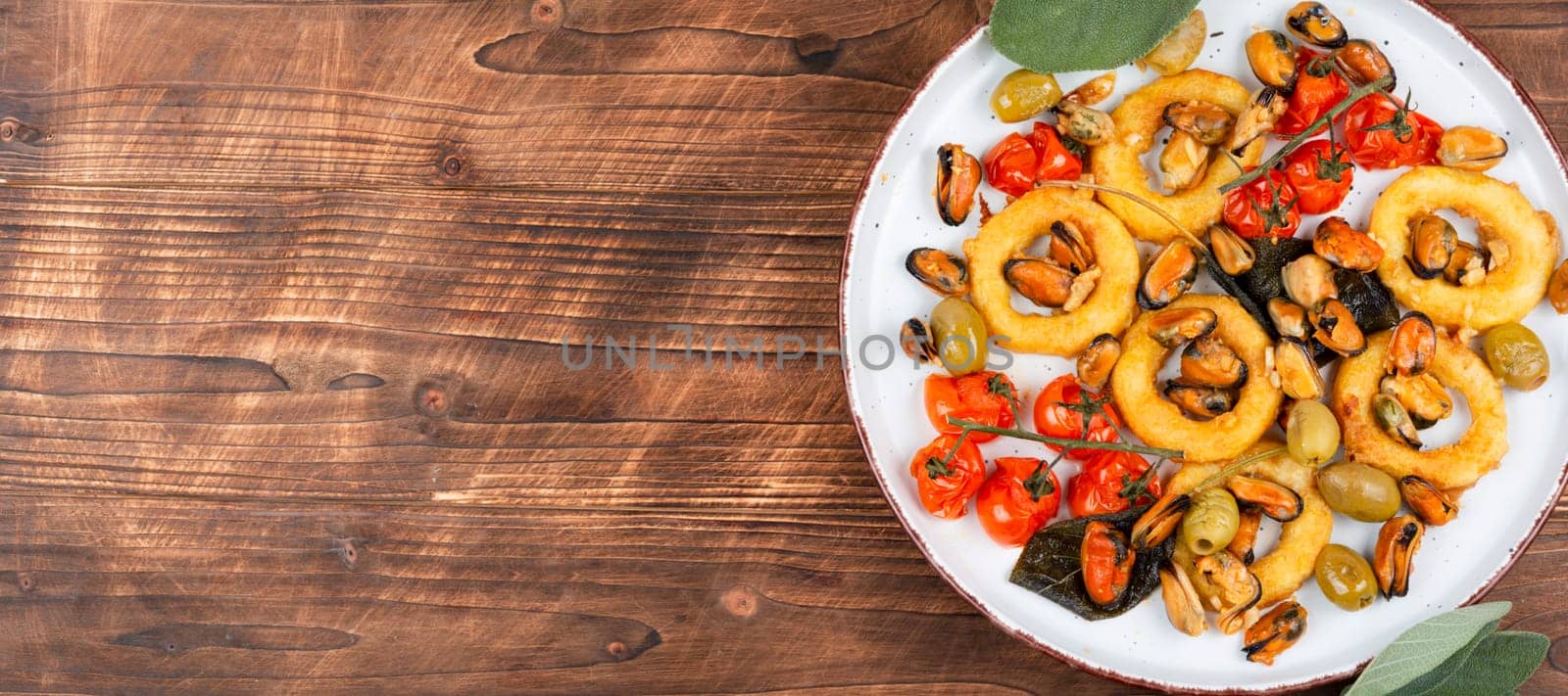 Delicious baked mussels and squid rings with sage. Exotic seafood platter. Space for text.