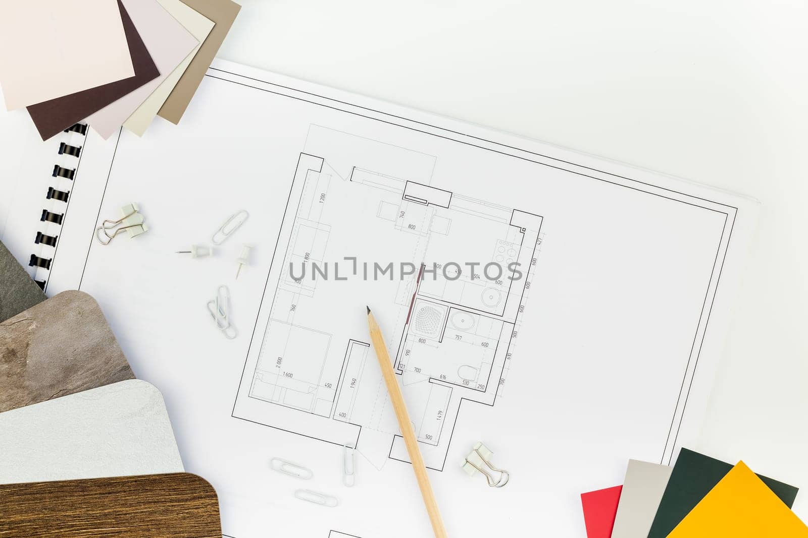 Creative flat lay overhead top view blueprints architectural flat project plan and office supplies on decorator white table workspace with swatches tools and equipment background copy space concept