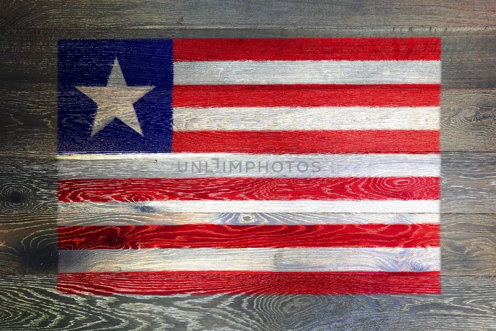 A Liberia flag on rustic old wood surface background red white blue stripes star