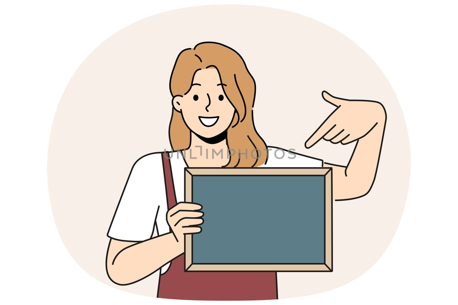 Woman waiter is holding chalkboard with copy space for drawing menu or promotional offers from restaurant. Cheerful girl waiter in apron points with finger at place for name of bar or cafe logo