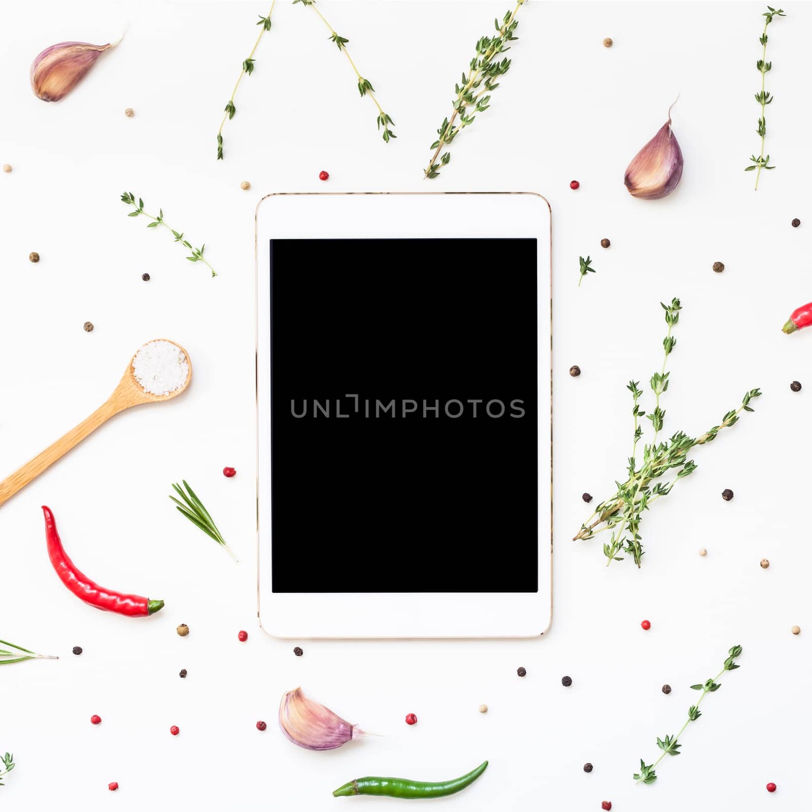 Flat lay overhead view tablet PC gadget mockup blank text space on white background with greens herbs and spices. Menu design food blog recipe cookbook or delivery app with cooking ingredients
