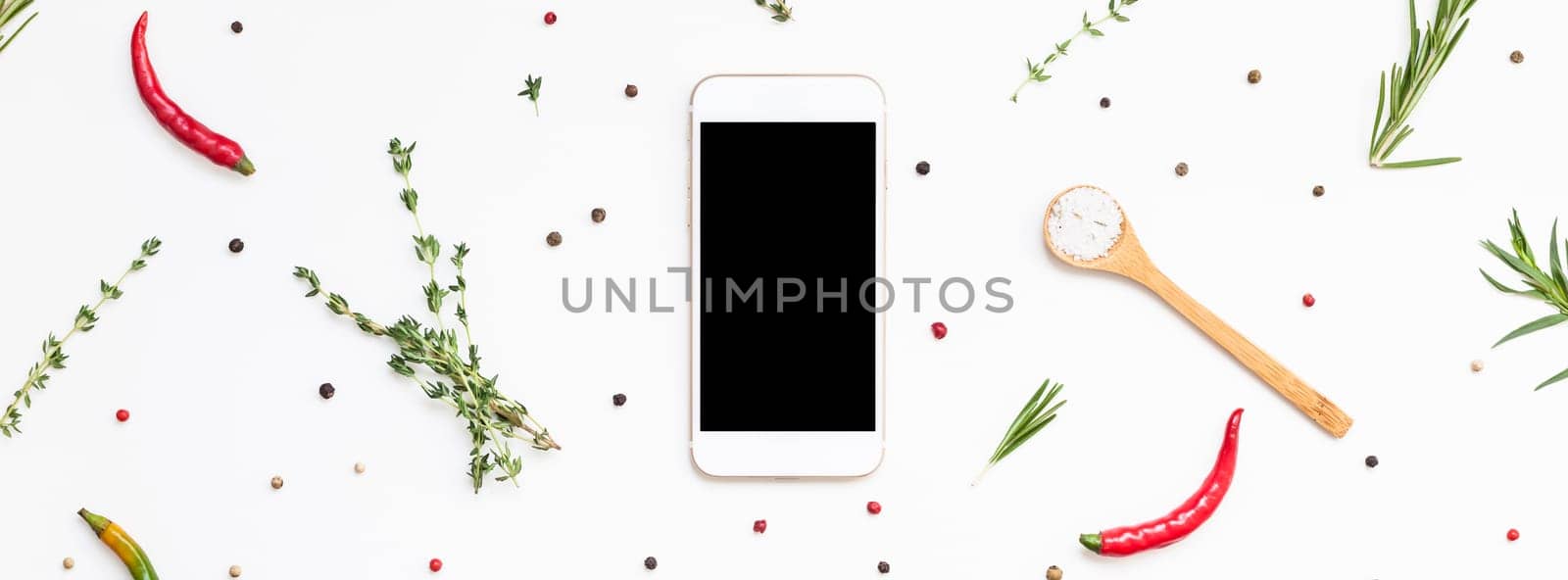 Flat lay overhead view smartphone mockup blank text space on white background with greens herbs and spices. Menu design food blog recipe cookbook or delivery app with cooking ingredients