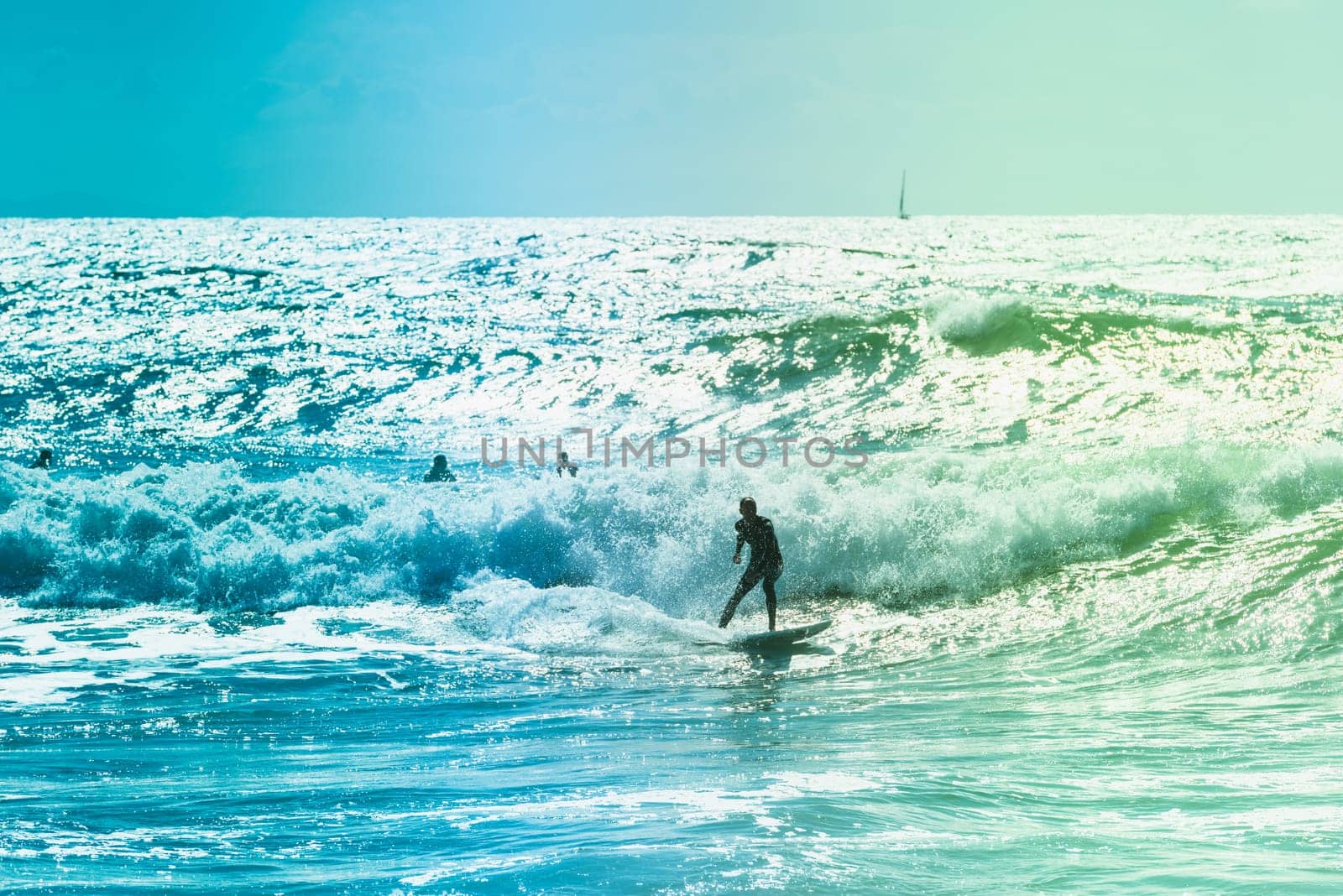 Extreme surfers riding some waves on the sea in France