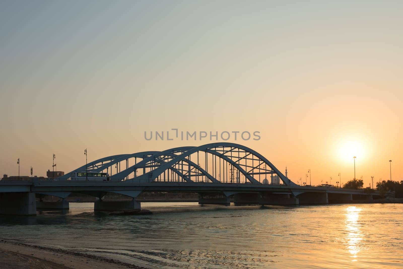 Maqta Bridge in Abu Dhabi, United Arab Emirates. Sunset view with water reflections