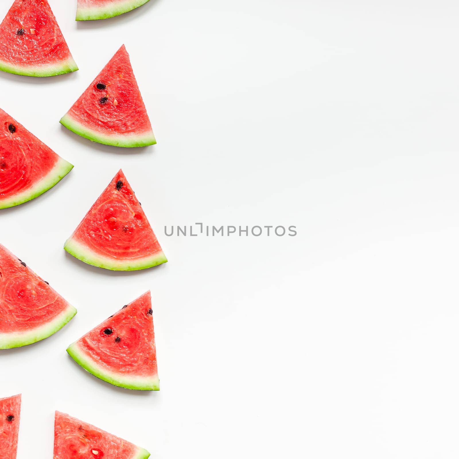 Creative scandinavian style flat lay top view of fresh watermelon slices on white table background copy space. Minimal summer fruits pattern for blog or recipe book