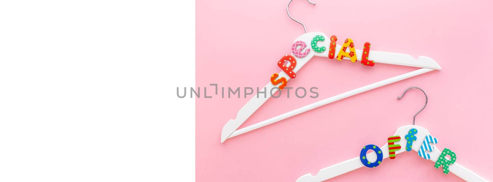 Creative top view flat lay white hangers special offer text pastel pink background copy space minimalism style. Template fashion feminine blog social media sale store promo design shopping concept