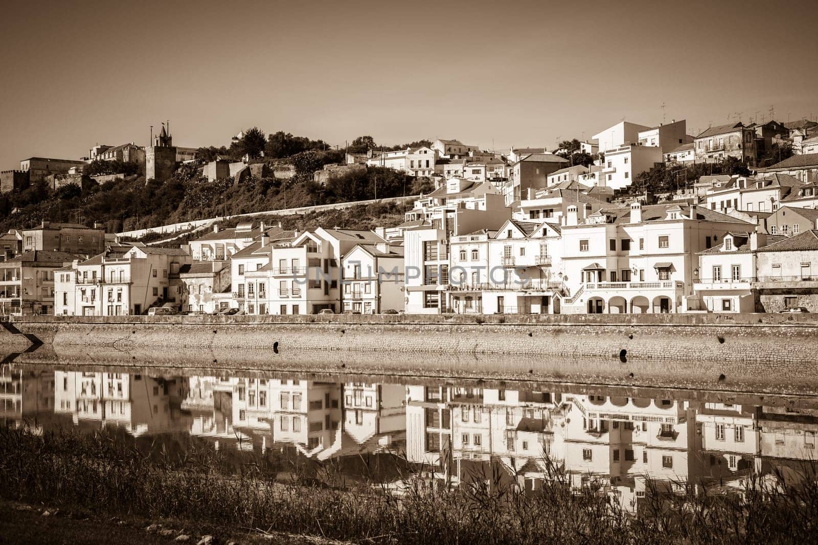 View of city Alcacer do Sal near the river Sado in Portugal. Horizontal sepia filtered shot