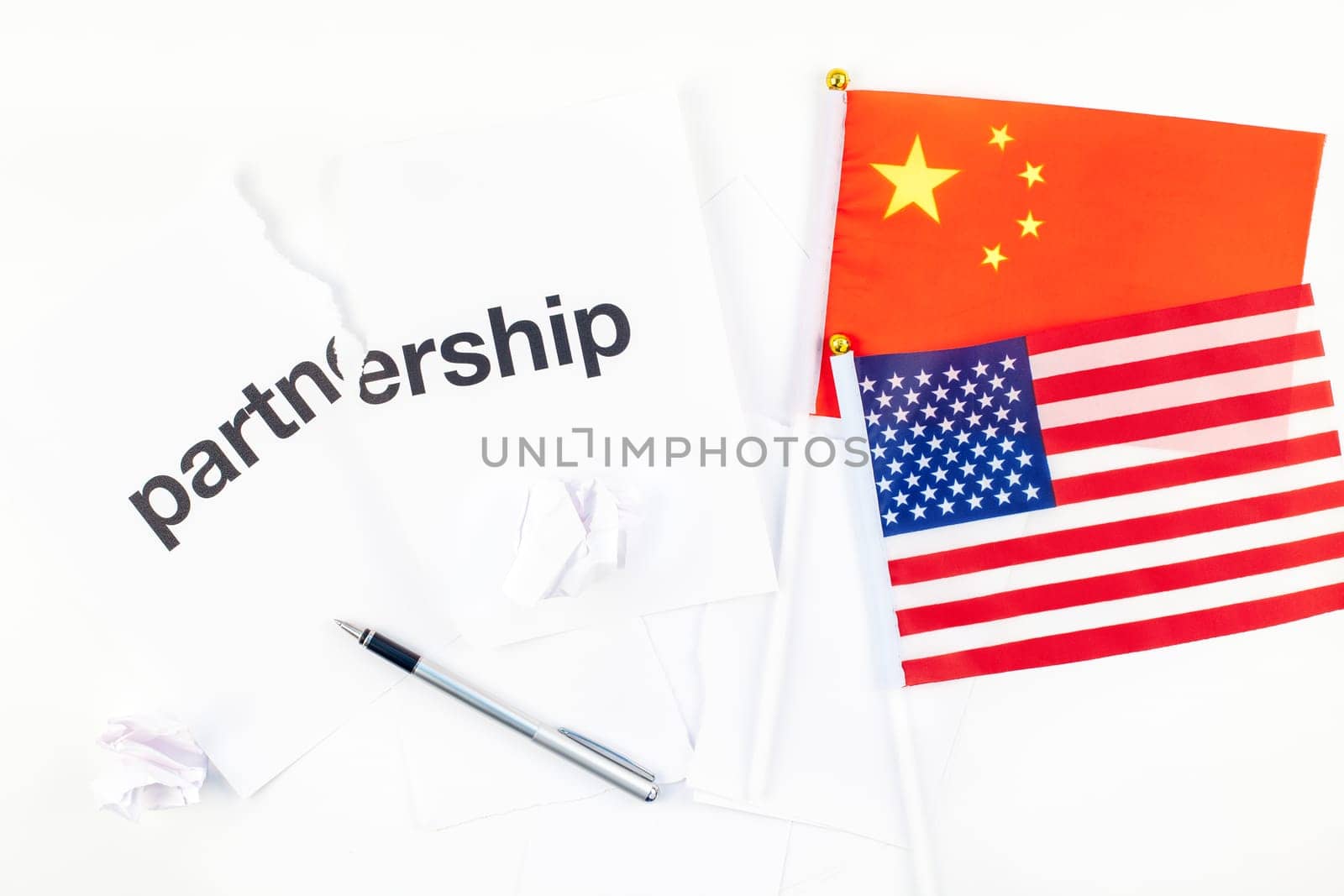 Creative top view flat lay of China and USA flag and broken partnership contract with pen and copy space on white background in minimal style. Concept of trade war between USA and China
