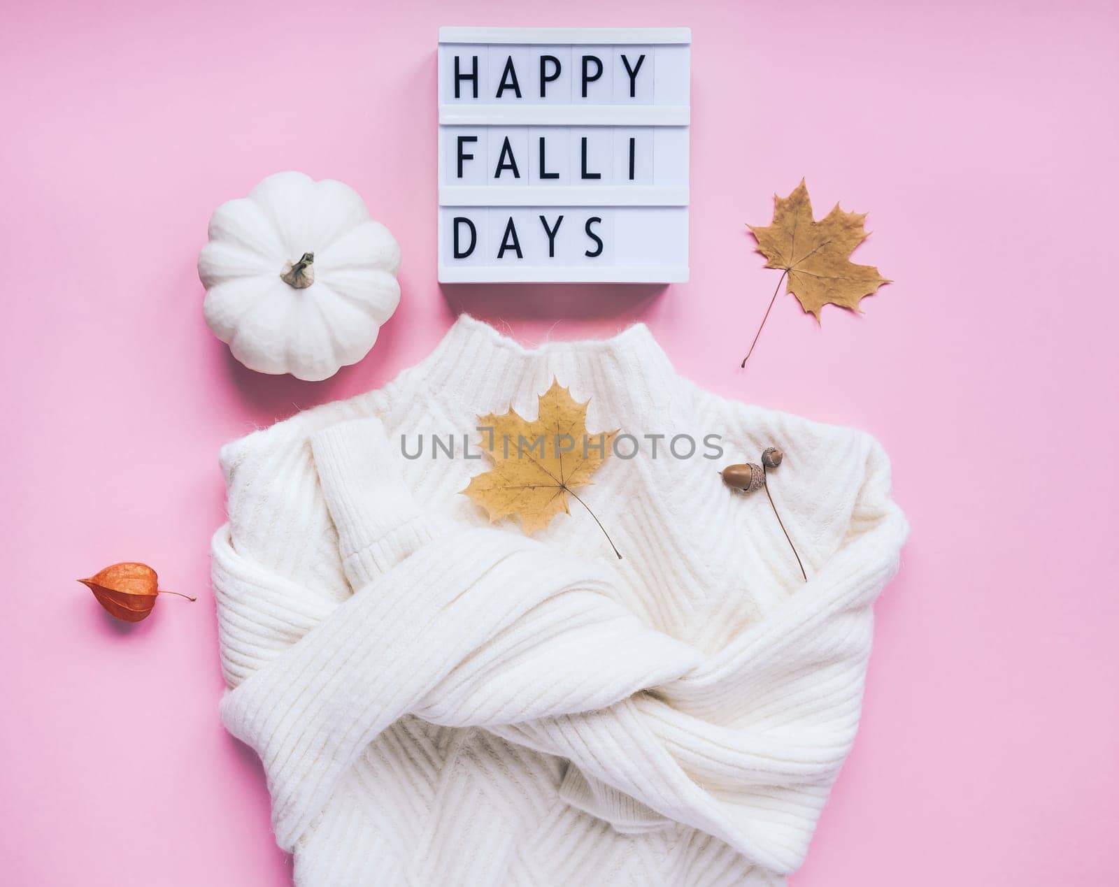 Creative autumn flat lay top view white cozy sweater pumpkin leaves lightbox Happy fallidays text on millennial pink background copy space minimal style Fall season composition for feminine blog
