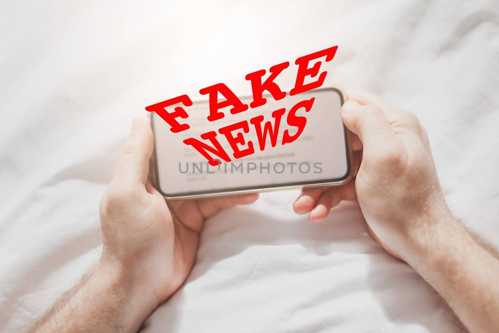 Fake news infodemics during Covid-19 pandemic concept. Man hands holding mobile phone reading global news or social net at home. Reading last news update in lockdown. Red text fake news on foreground
