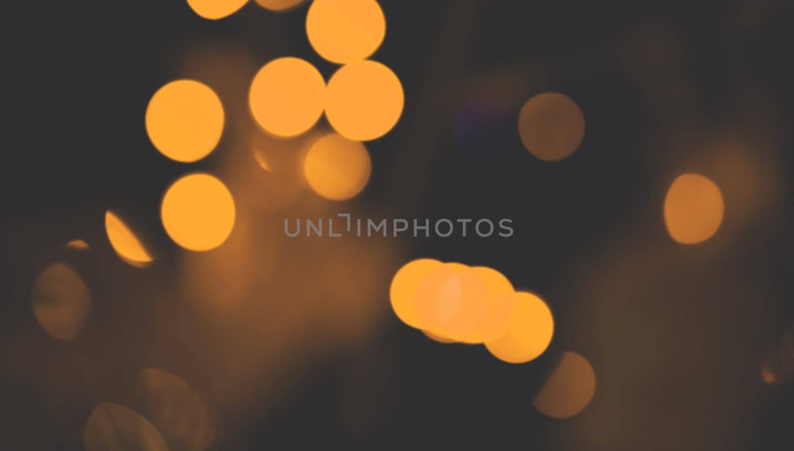 Red Christmas garland blurred and defocused with bokeh on a dark background