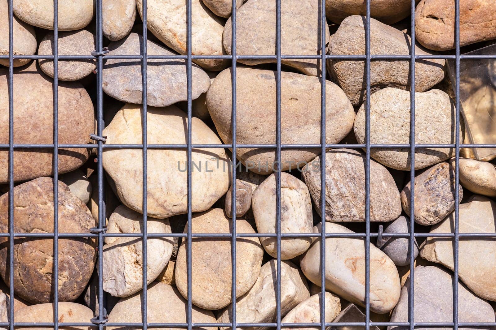 metallic basket net filled by natural stones as a fence