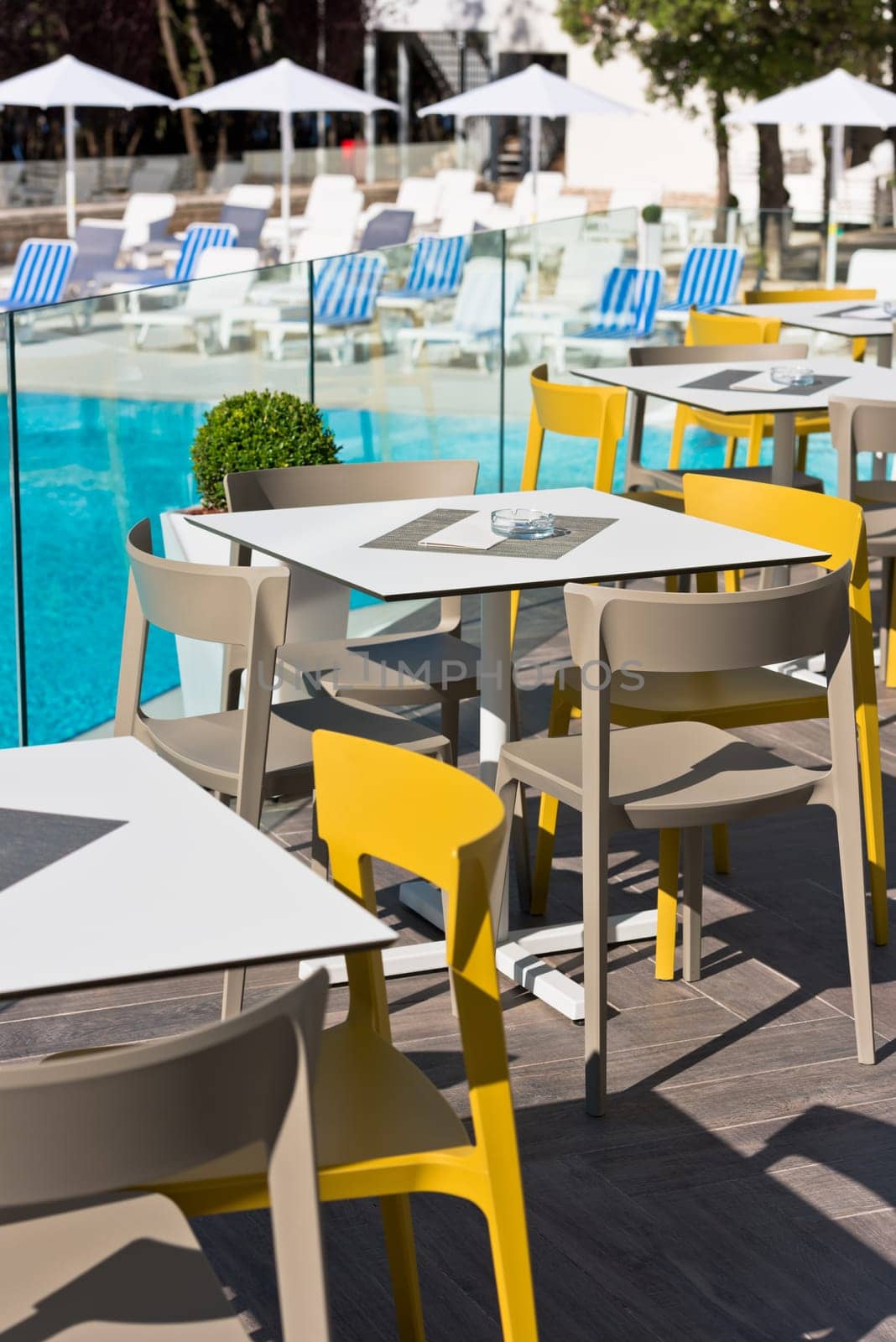 Summer cafe with plastic furniture near swimming pool