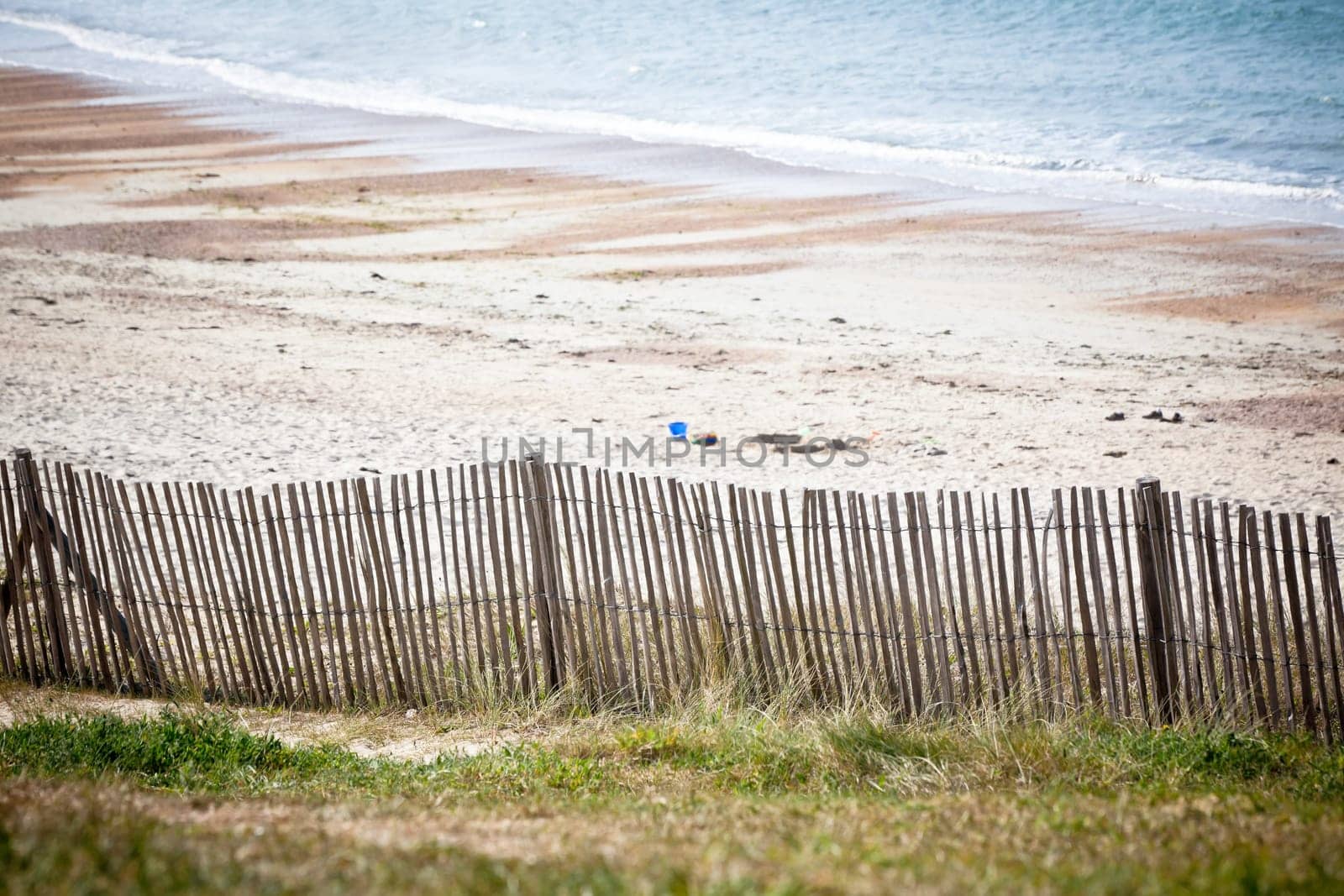 Wooden fence at Northern sea beach in France. Horizontal shot