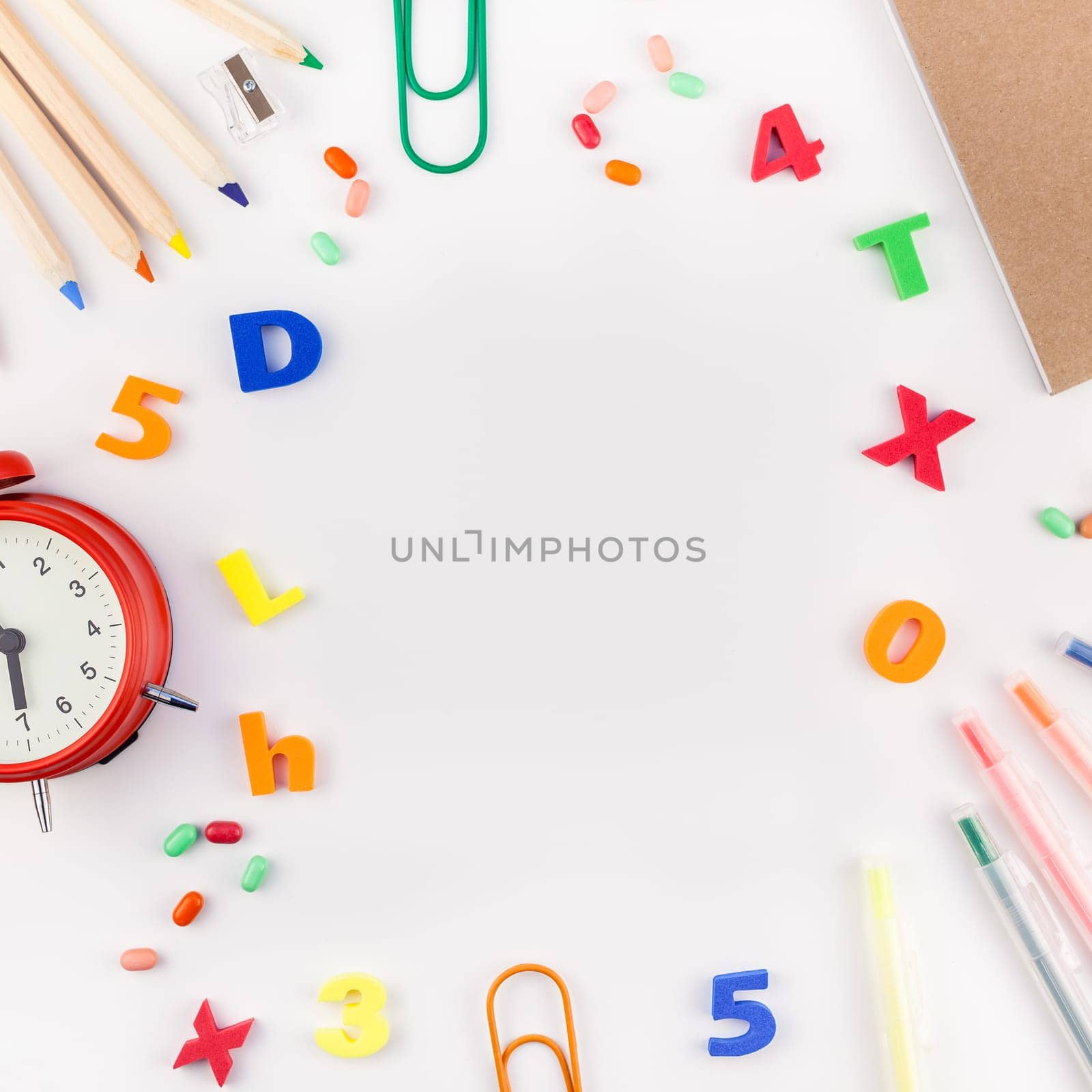 Square flat lay back to school concept with alarm clock, color school and office supplies on white table background with copy space, frame, template for text or design