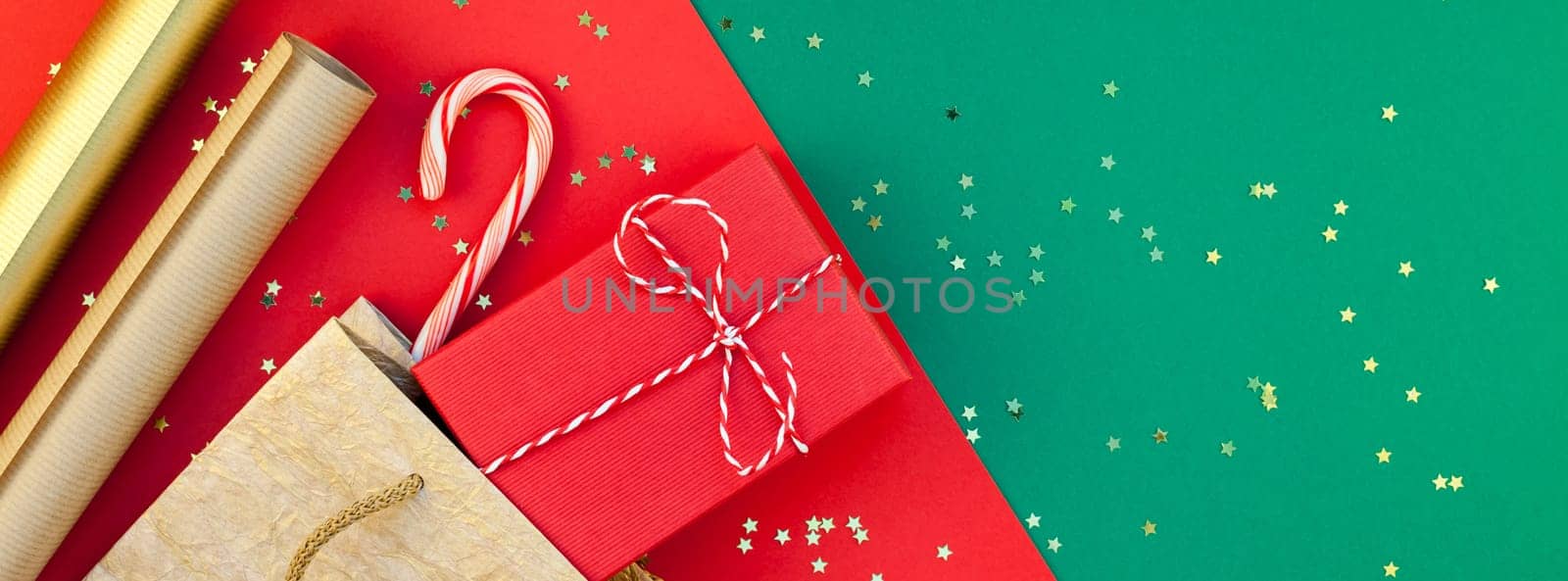 New Year or Christmas presents preparation DIY flat lay top view Xmas holiday celebration handmade gift boxes on red green paper background. Template mockup for greeting card long wide banner 2019