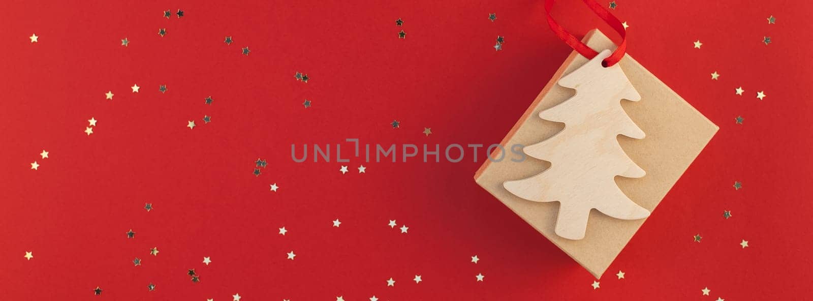 New Year or Christmas present flat lay top view Xmas 2019 holiday celebration handmade gift box red paper golden sparkles background copyspace. Template mockup for greeting card long wide banner