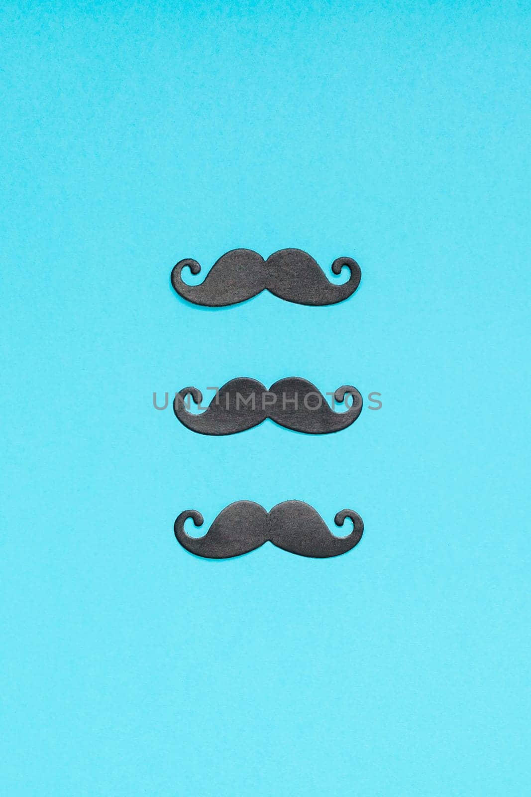 Creative flatlay overhead top view retro stylish black paper photo booth props moustaches turquoise background copy space. Men health awareness month fathers day masculinity concept blog social media