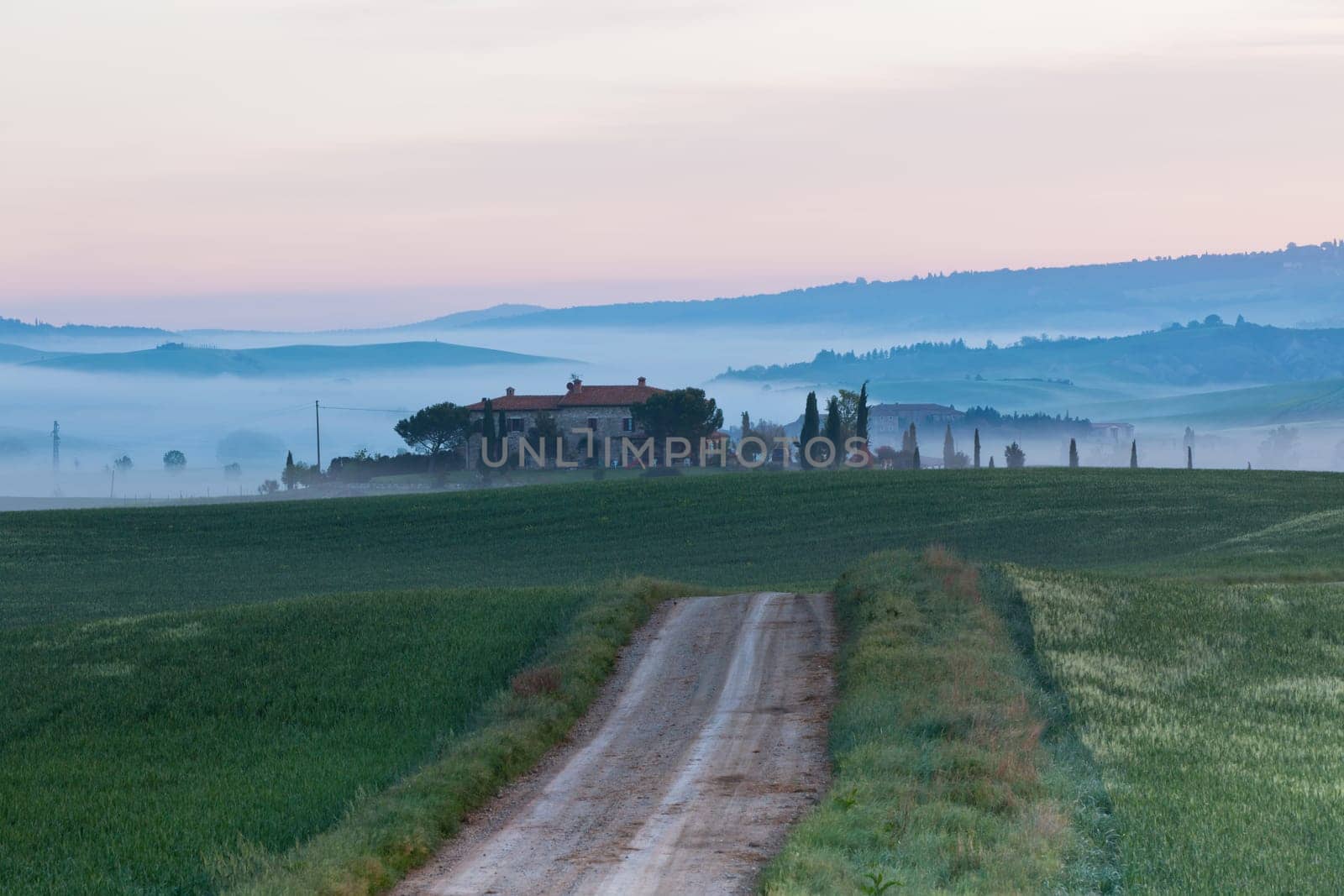 Morning fog view on farmhouse at Valley d?Orcia in Tuscany, Italy.