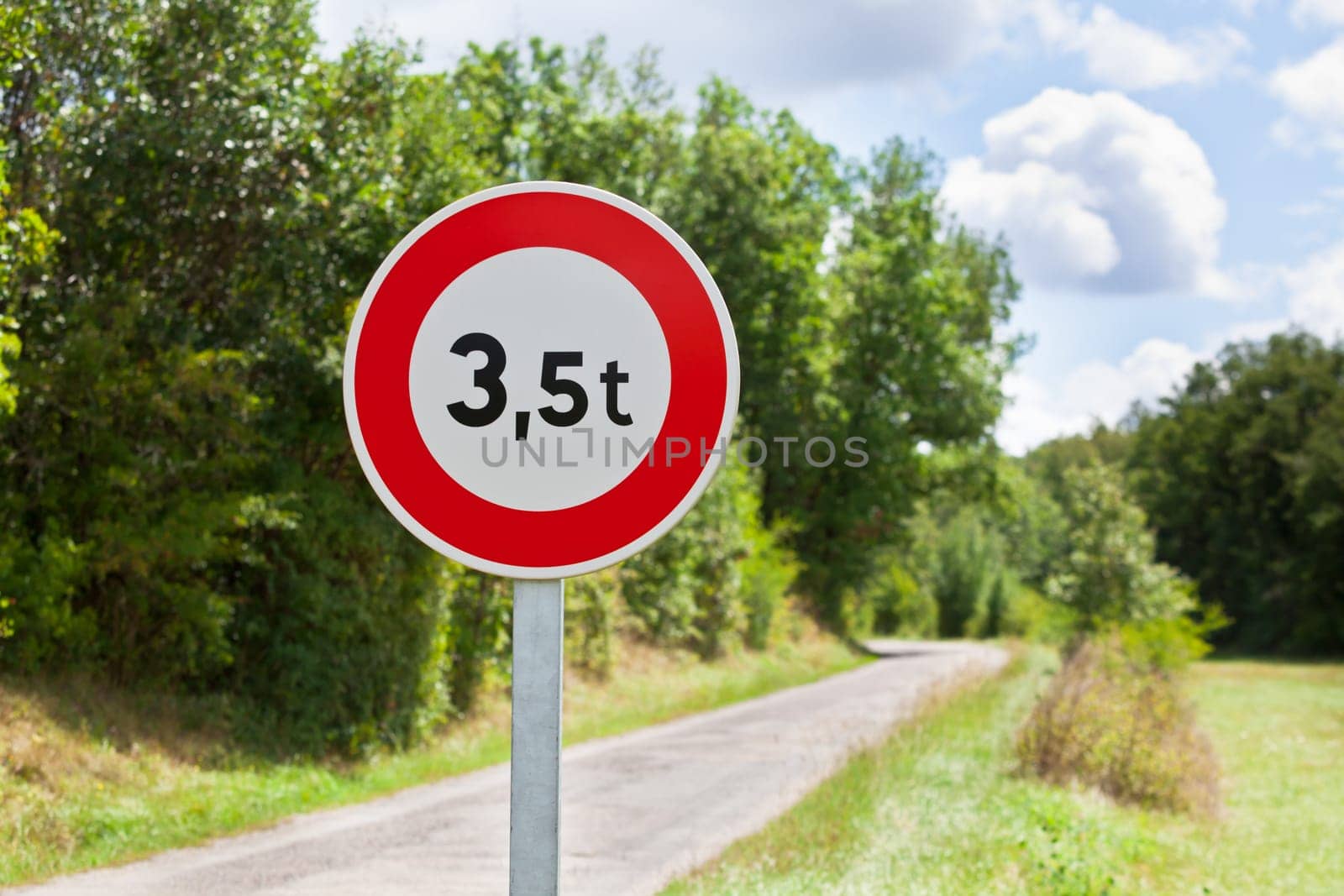 Traffic sign of 3,5 tons weigh restriction on a rural road background