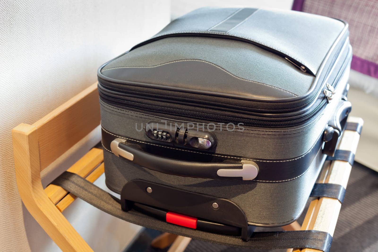 Hotel room with a suitcase on the luggage place