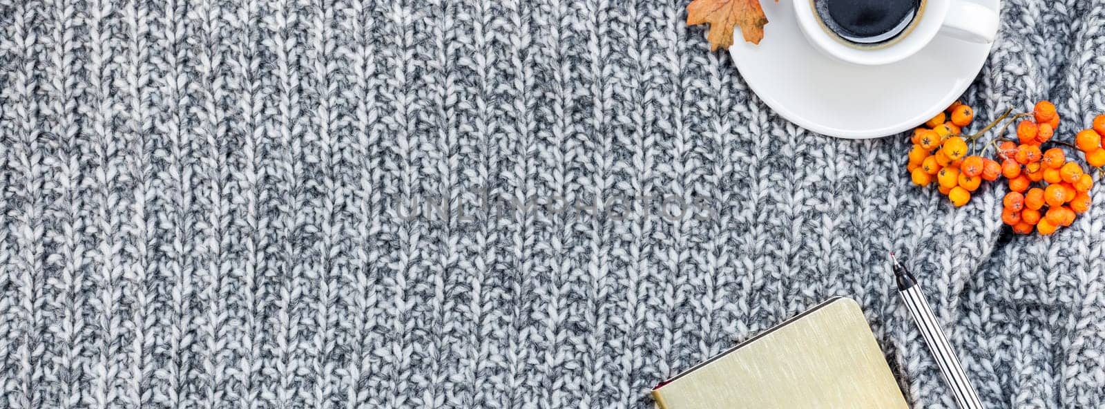 Creative autumn flat lay overhead top view stylish home workspace with notebook coffee cup cozy gray knitted plaid long wide banner copy space. Fall season template feminine blog social media