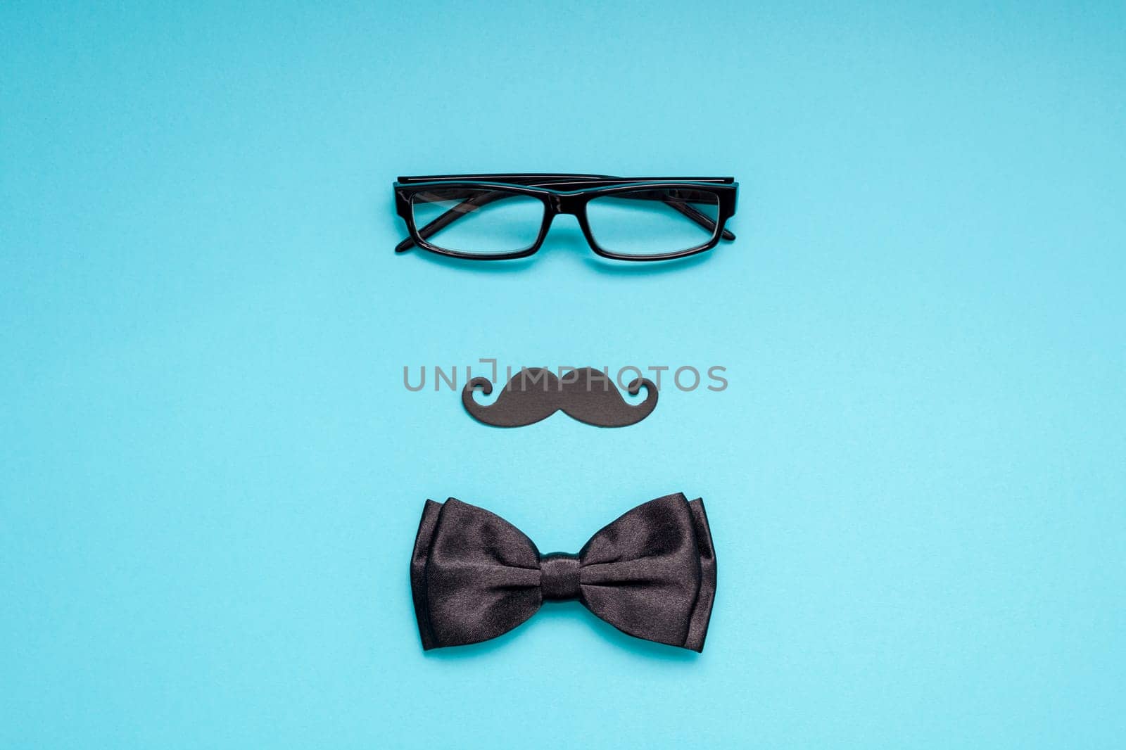 Creative flatlay overhead top view retro stylish black paper photo booth props moustaches turquoise background copy space. Men health awareness month fathers day masculinity concept blog social media