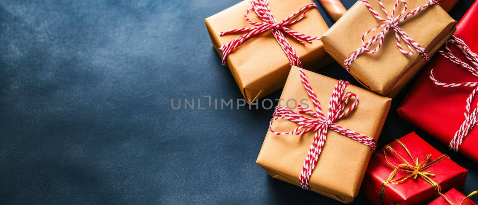 A collection of wrapped gifts with red and gold accents on a dark surface, perfect for holiday celebrations.