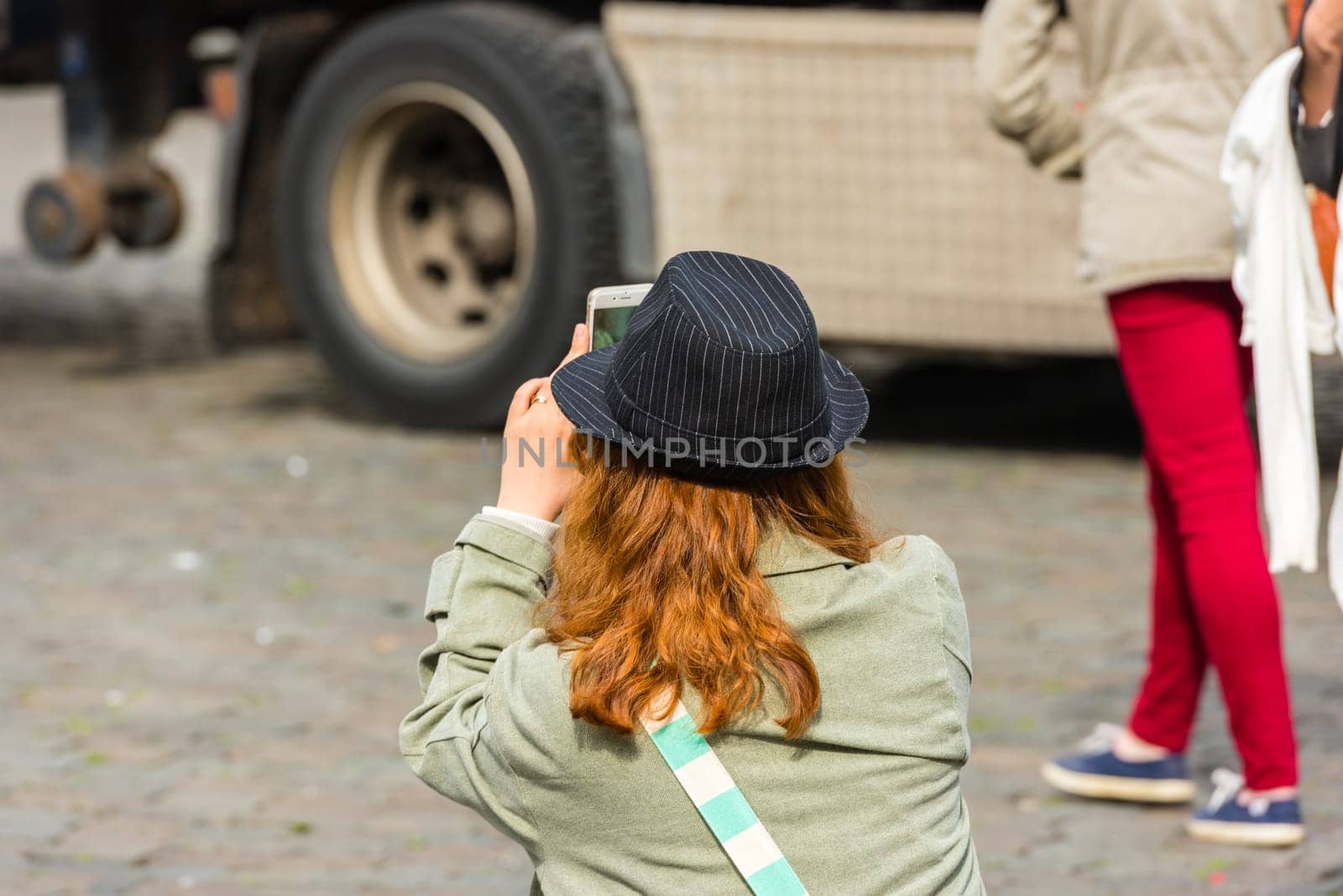 BELGIUM, BRUSSELS - MAY 25: Back side of a young woman taking a photo with her camera on May 25, 2015