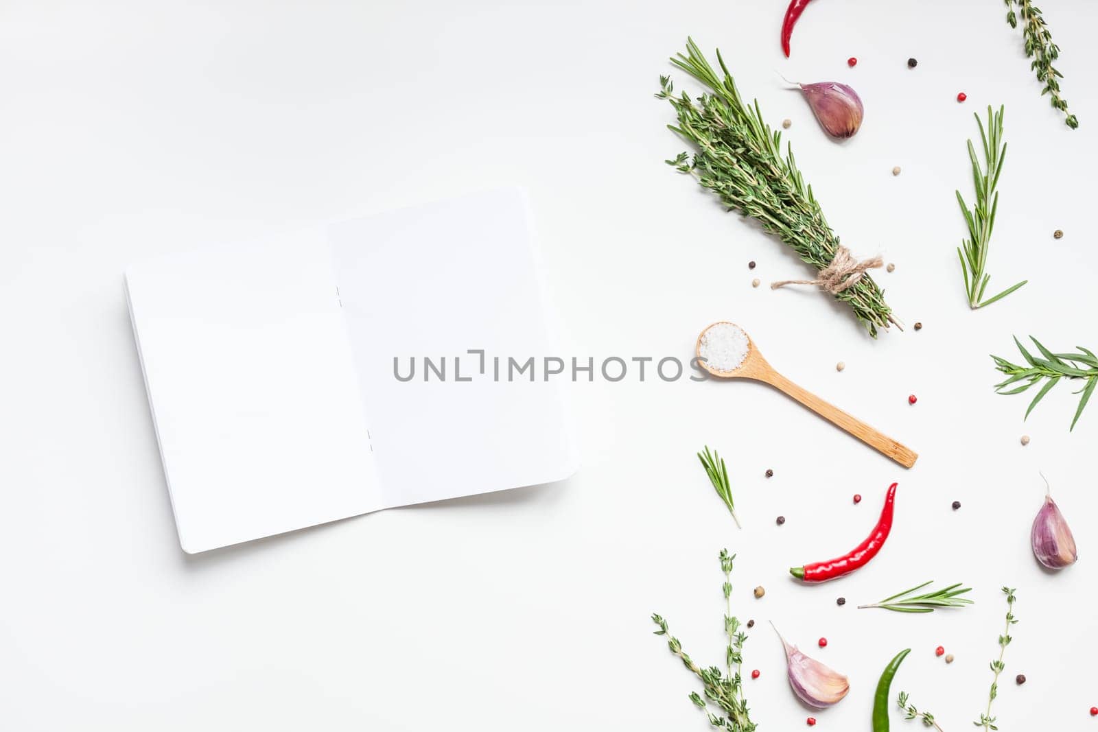 Flat lay overhead view blank notebook pages mockup text space invitation card on white background with greens herbs and spices. Menu or recipe book or food blog design with cooking ingredients