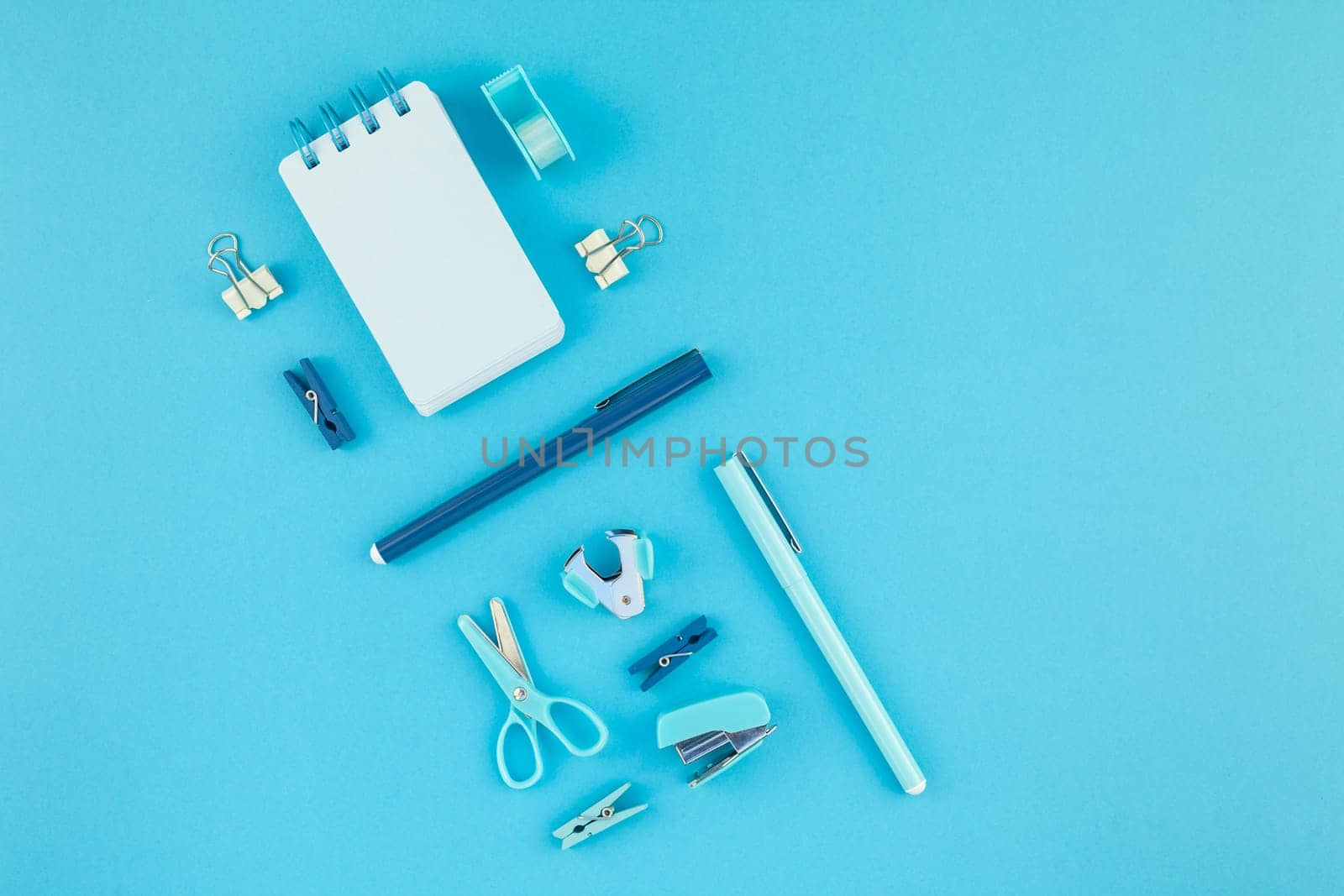 Top view knolling flat lay of workspace desk styled design school and office supplies with copy space turquoise blue color paper background minimal style. Template for feminine blog social media